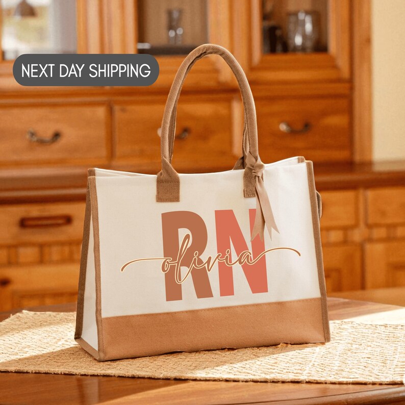A white tote bag with the word "RN" printed on it, sitting on a wooden surface.