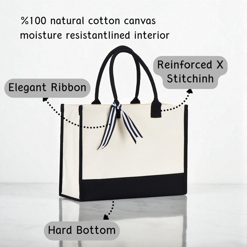 a white tote bag with a black and white ribbon tied around it, and it has a hard bottom.