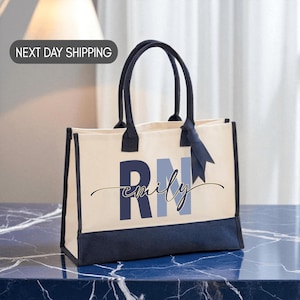 A beige tote bag with the name "Emilly" printed on it, sitting on a marble countertop.