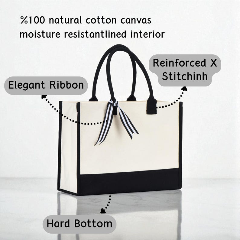 a white tote bag with a black and white ribbon tied around it, and it has a hard bottom.