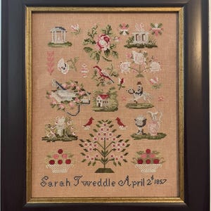 May include: A framed cross-stitch sampler on tan fabric featuring various motifs including buildings, flowers, a bird, a horse and rider, and trees. The text at the bottom reads Sarah Tweddle April 2nd 1857. The piece is enclosed in a black frame with gold trim.