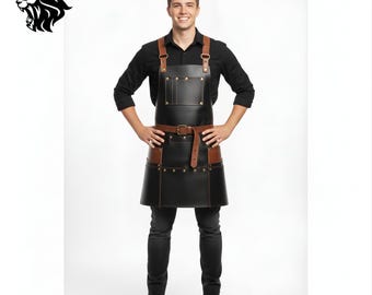May include: A black leather apron with brown leather accents, including straps and a belt. The apron has a pocket on the chest and is worn by a person. The apron is designed for use in a kitchen or workshop.