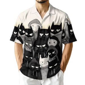 Könnte beinhalten: Weißes Hemd mit Knöpfen und einem sich wiederholenden Muster aus schwarz-weißen Cartoon-Katzen mit Kapuzenpullovern. Die Katzen haben verschiedene Gesichtsausdrücke, einige wirken mürrisch. Das Hemd hat kurze Ärmel und einen Kragen.