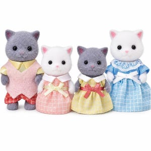 May include: Four flocked cat figurines standing in a row. The first is a gray cat in a pink vest and red plaid pants. The second is a white cat in a pink plaid dress. The third is a gray cat in a yellow plaid dress. The fourth is a white cat in a blue plaid dress.