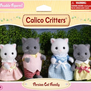 May include: A Calico Critters Persian Cat Family set featuring four posable cat figures in a box. The figures include two white cats and two gray cats wearing fabric clothing, including dresses, a vest, and trousers, with the text Persian Cat Family.
