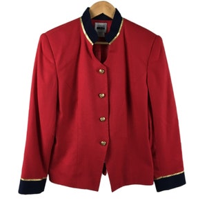 May include: Red blazer with gold buttons and a black and gold trim collar. The blazer has long sleeves with black and gold trim cuffs.