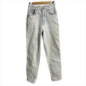 May include: Light blue acid wash jeans hanging on a wooden hanger. The high-waisted jeans have a classic five-pocket design and a straight leg cut. The denim has a faded, textured appearance with light and dark blue tones.