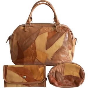 Puede incluir: Un bolso de mano tipo patchwork en tonos marrones, una cartera rectangular con cierre de botón a presión y un pequeño estuche ovalado con cremallera. Cada pieza está hecha de retazos de cuero en tonos beige, ocre y marrón oscuro.