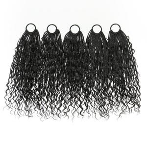 Puede incluir: Cinco mechones de extensiones de cabello rizado negro, cada uno unido a un anillo negro. El cabello está muy rizado y cuelga, creando un aspecto lleno y voluminoso. El fondo es blanco liso.