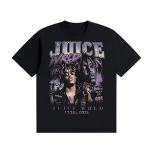 Pode incluir: Uma t-shirt preta de manga curta com uma impressão gráfica de Juice WRLD. O design inclui o texto JUICE WRLD, 999, LEGENDS NEVER DIE e 1998-2019. O gráfico exibe vários retratos do artista em tons de roxo e preto.