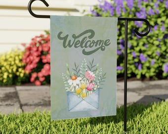 May include: A welcome garden flag with a blue background and a watercolor design of flowers in an envelope. The text "Welcome" is written in a stylized font.