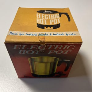 May include: Vintage cardboard box for an electric hot pot. The box is tan with a black and white graphic of the hot pot and the words "ELECTRIC HOT POT". The box also has the words "Ideal for instant drinks & instant foods".