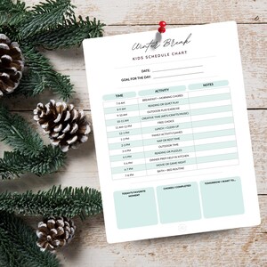 May include: A white "Winter Break" Kids Schedule Chart pinned with a red pin. The chart lists activities like breakfast, reading, and outdoor play. The chart is framed by pinecones and evergreen branches, creating a festive look.
