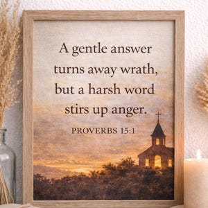 May include: A framed print displaying the text "A gentle answer turns away wrath, but a harsh word stirs up anger. PROVERBS 15:1." The image shows a sunset with a church silhouette. The frame is light brown.