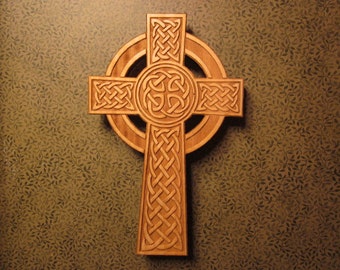 May include: A wooden Celtic cross with intricate knotwork designs. The cross is carved from a light brown wood and has a circular halo around the center.