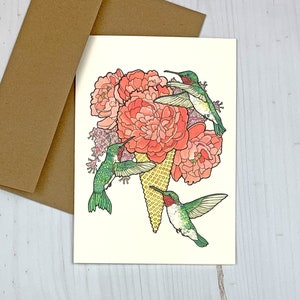 May include: A greeting card featuring a whimsical illustration of three hummingbirds hovering around a cone of ice cream topped with pink peonies.