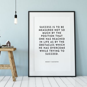 May include: Black and white framed print with a quote by Booker T. Washington: "Success is to be measured not so much by the position that one has reached in life as by the obstacles which he has overcome while trying to succeed."