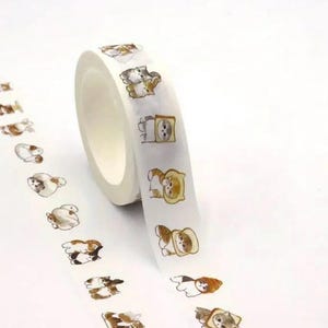 Könnte beinhalten: Eine Rolle dekorativen Washi-Tapes mit einem sich wiederholenden Muster von Cartoon-Katzen. Die Katzen sind in verschiedenen Posen und Farben dargestellt, darunter Braun, Grau und Weiß. Einige tragen Hüte oder sind in Brot eingewickelt. Das Tape befindet sich auf weißem Hintergrund.