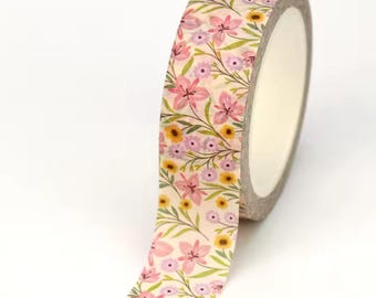 May include: A roll of floral washi tape featuring a repeating pattern of pink lilies, yellow and purple flowers, and green leaves on a cream background. The tape is partially unrolled, revealing the inner cardboard core.