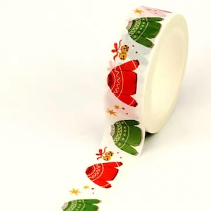 Op de afbeelding: Rol decoratieve washi tape met een herhalend patroon van rode en groene truien, gouden sterren en belletjes op een witte achtergrond. Ideaal voor knutselen, scrapbooking en cadeauverpakking.