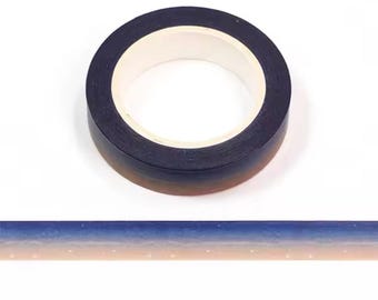 May include: A roll of washi tape with a gradient design. The tape transitions from a dark navy blue to a light brown color. The tape is on a white background. A strip of the tape is shown below the roll, displaying the gradient.