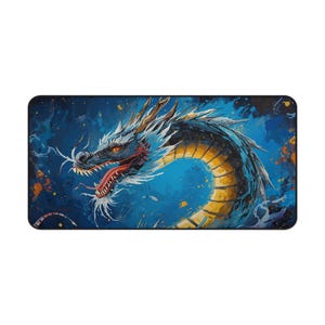 May include: A rectangular desk mat featuring a detailed illustration of a dragon. The dragon is depicted in shades of blue, yellow, and red against a blue background with paint splatters. The dragon's head is in profile, with its mouth open.