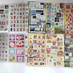 May include: A collection of sticker sheets featuring various cartoon characters and decorative elements. The stickers include images of animals, food, and text bubbles. The sheets are clear with a variety of colors and designs, suitable for scrapbooking or crafts.