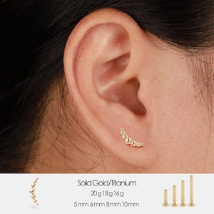 May include: A gold-colored curved earring with a series of small, round beads is shown on an ear. The text "Solid Gold/Titanium" and size details are also visible: 20g 18g 16g, 5mm 6mm 8mm 10mm.