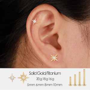 May include: Gold starburst stud earrings with a central clear gemstone, shown on an ear. The text "Solid Gold/Titanium" is visible, along with size options: 5mm, 6mm, 8mm, and 10mm.