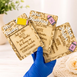 Könnte beinhalten: Drei Holztafeln zur Wertschätzung von Lehrern mit personalisierten Namen und der Botschaft "Just a little NOTE to say thanks for being an awesome teacher." Jede Tafel hat einen Bleistift- oder Buntstiftakzent.
