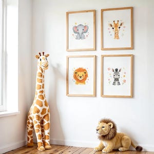 Puede incluir: Una habitación con una gran jirafa de peluche y un león de peluche en el suelo. Cuatro impresiones enmarcadas de animales cuelgan en la pared, con un elefante, una jirafa, un león y una cebra. Las impresiones son de estilo acuarela.