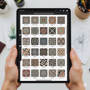 May include: A digital tablet displaying a Procreate brush set with 32 patterns. The screen shows various intricate designs, including floral, geometric, and abstract motifs. The text "32 pattern brushes for procreate.brushset" is visible at the top.