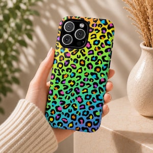 May include: A colorful phone case with a vibrant leopard print design. The case features a gradient of colors, including orange, yellow, green, blue, and purple. The case has a glossy finish and is designed to fit a smartphone.