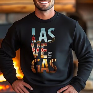 May include: Black sweatshirt with the text "LAS VEGAS" in a colorful, layered design. The design incorporates images of the city's landmarks and the words "Fabulous Nevada" and "United States of America".