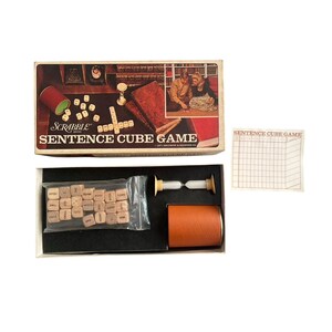 May include: Vintage Scrabble Sentence Cube Game box set. The box features a brown and tan color scheme with the game title prominently displayed. Includes wooden cubes, a timer, and a score sheet.