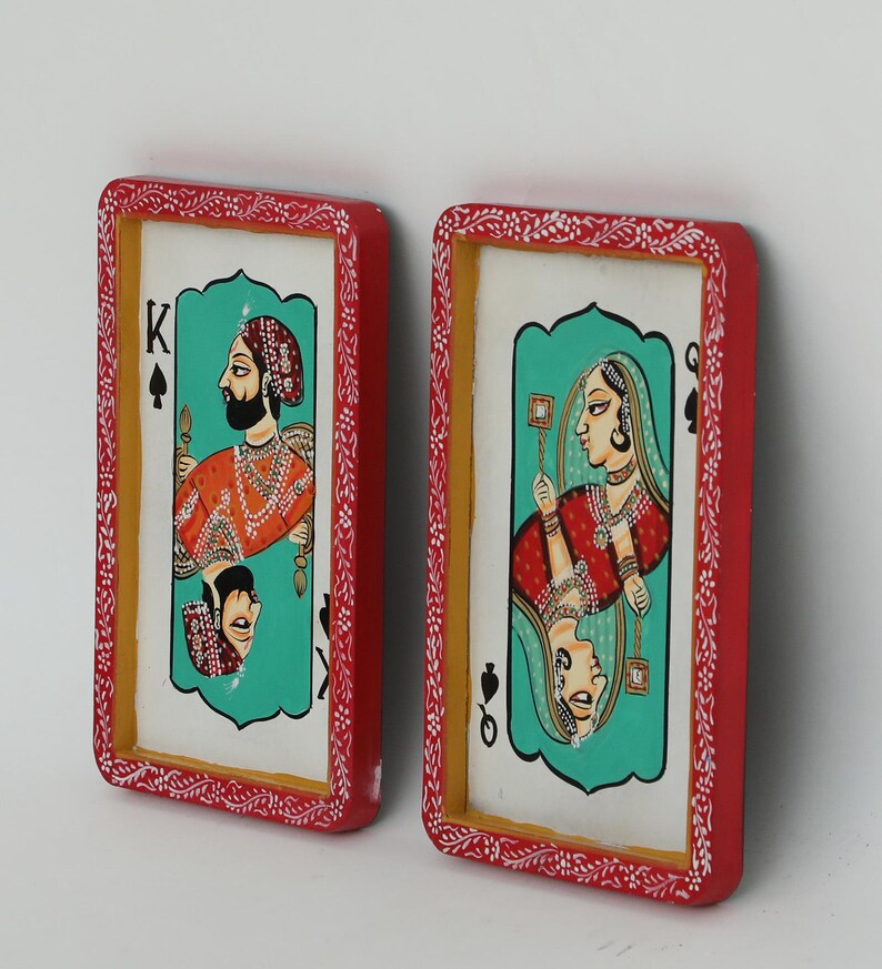 K&ouml;nnte beinhalten: Zwei gerahmte Spielkarten-Kunstwerke. Eines zeigt einen K&ouml;nig in Orange und Gold, das andere eine K&ouml;nigin in Rot und Gold. Beide Karten haben einen t&uuml;rkisfarbenen Hintergrund und sind rot mit wei&szlig;en floralen Details gerahmt.