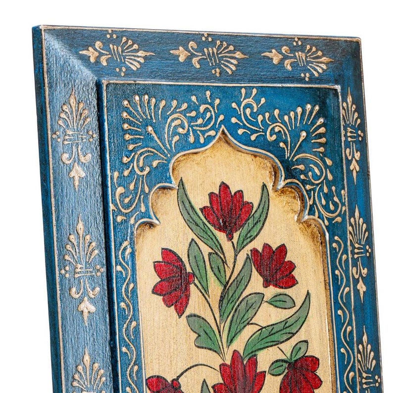 May include: A rectangular wooden wall art piece with a blue frame and a central panel featuring a floral design. The flowers are red with green leaves, set against a beige background. The frame has gold accents.