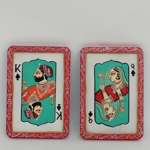 K&ouml;nnte beinhalten: Zwei rechteckige Kunstwerke im Spielkarten-Design. Eines zeigt einen K&ouml;nig in Orange und Gold, das andere eine K&ouml;nigin in Rot. Beide haben einen t&uuml;rkisfarbenen Hintergrund, einen wei&szlig;en Rand und einen roten dekorativen Rahmen. Die Karten sind mit den Buchstaben "K" und "Q" markiert.