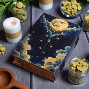 May include: A decorative book with a celestial design featuring a full moon, crescent moons, and clouds. The book is surrounded by candles, small glass jars, and a wooden spoon, creating a mystical and enchanting atmosphere.