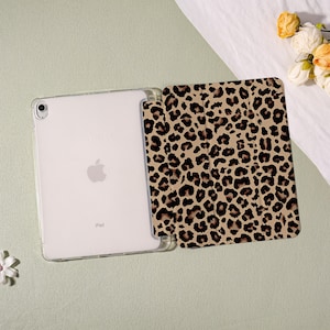 May include: An iPad in a clear case with a leopard print cover. The cover is tan with dark brown spots. The iPad is white with the Apple logo visible. The case is open, revealing the screen.