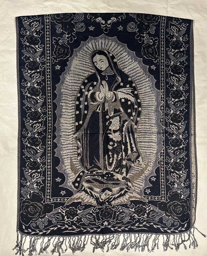 May include: A dark blue tapestry depicting the Virgin Mary with a halo, stars, and an angel. The tapestry has a floral border in shades of grey and black, and a fringed edge. The image is a religious theme.