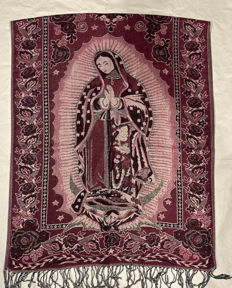 May include: Burgundy tapestry depicting the Virgin Mary with a halo, stars, and floral border. The tapestry has a fringed bottom and is made of woven fabric. The image shows the Virgin Mary with hands clasped in prayer.
