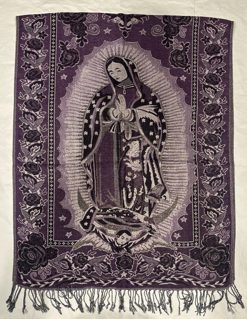 May include: A purple tapestry depicting the Virgin Mary in prayer, with a floral border of roses and a fringed edge. The image is detailed with silver and grey accents. The tapestry is likely made of woven fabric.