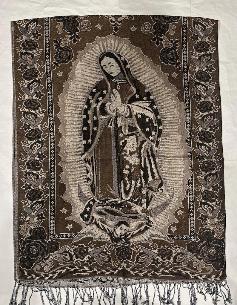 May include: A brown and grey tapestry depicting the Virgin Mary with a halo, stars, and a crescent moon. The tapestry has a floral border and fringe at the bottom. The image is a religious depiction.