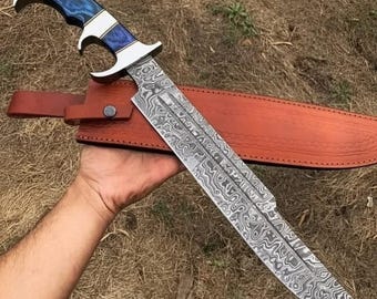 Cuchillo de exterior de acero de Damasco: hoja forjada con funda de cuero y mango decorativo.