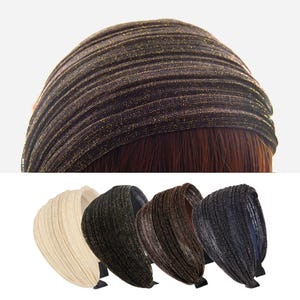 Könnte beinhalten: Eine Auswahl an breiten Stirnbändern in verschiedenen Farben. Das obere Stirnband ist dunkelbraun mit goldenen Metallicfäden. Darunter befinden sich Stirnbänder in Creme, Dunkelgrün, Braun und Dunkelgrau. Jedes Stirnband hat ein breites, gerafftes Design und ein schwarzes Band.
