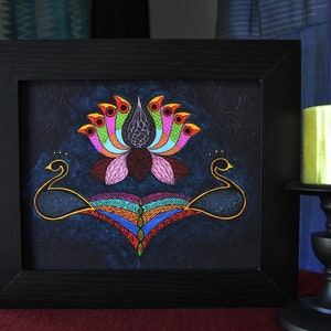 May include: A framed painting of a colorful lotus flower with two black peacocks on either side. The background is a dark blue with a starry effect.