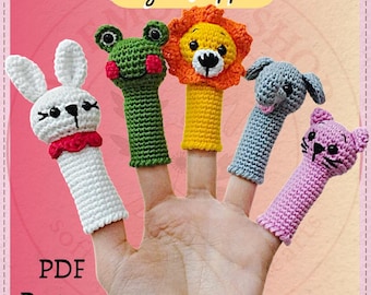 May include: A hand displays five crocheted finger puppets: a white bunny, a green frog, a yellow lion, a gray elephant, and a pink cat. The puppets are detailed with black eyes and other features. The image includes the text "Finger Puppets" and "PDF Pattern".