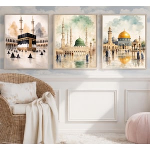 Puede incluir: Conjunto de tres láminas enmarcadas de acuarela que representan lugares sagrados islámicos. La obra de arte presenta la Kaaba, una mezquita con una cúpula verde y una mezquita con una cúpula dorada. Las láminas tienen una paleta de colores suaves.