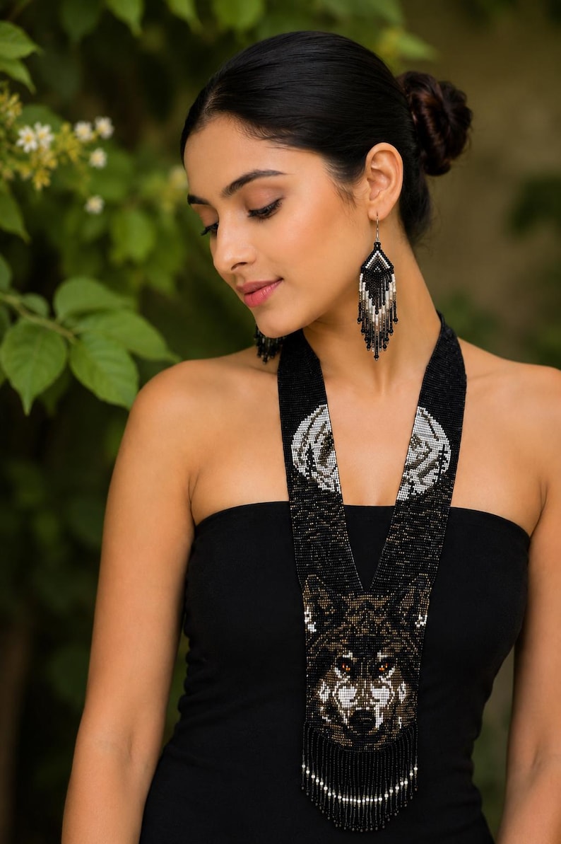 Model wearing a handcrafted wolf seed bead statement necklace and matching fringe earrings inspired by wildlife and forest spirit.
